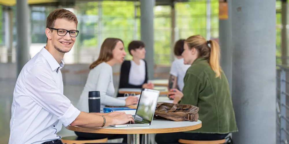 Studierende reden und lernen in der Cafeteria 