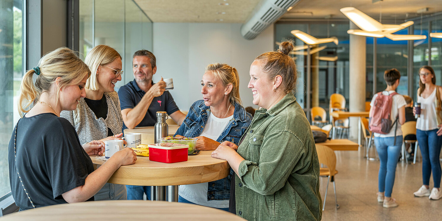 Studierende unterhalten sich in der Cafeteria.