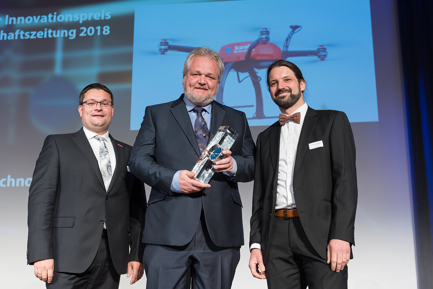 Florian Olbrich (rechts) und Robert Schmidkonz (Mitte) von der Scarabot Technologies GmbH nahmen von Laudator Alexander Stahl, Geschäftsführer der Handwerkskammer Niederbayern-Oberpfalz, den Innovationspreis der Wirtschaftszeitung entgegen.