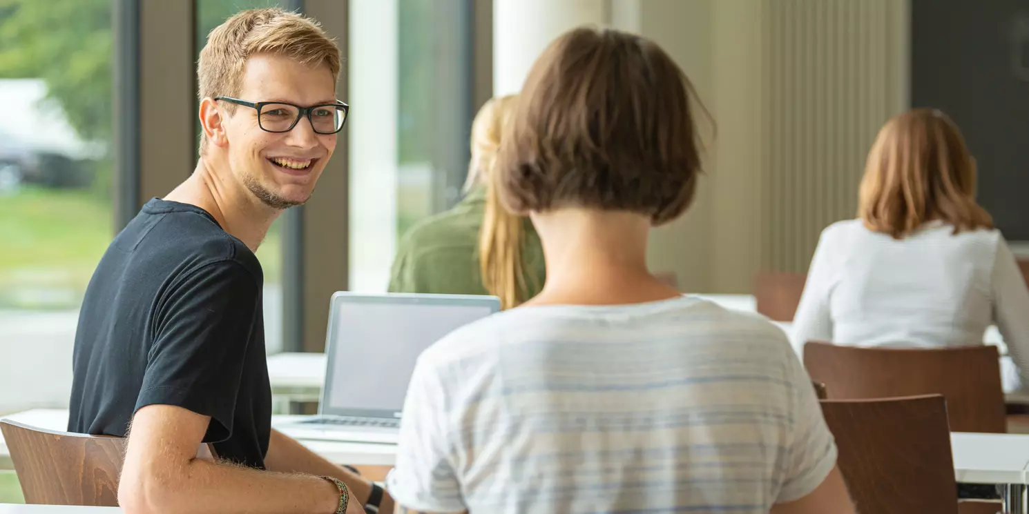 Studierende arbeiten und lernen in einem Seminarraum.