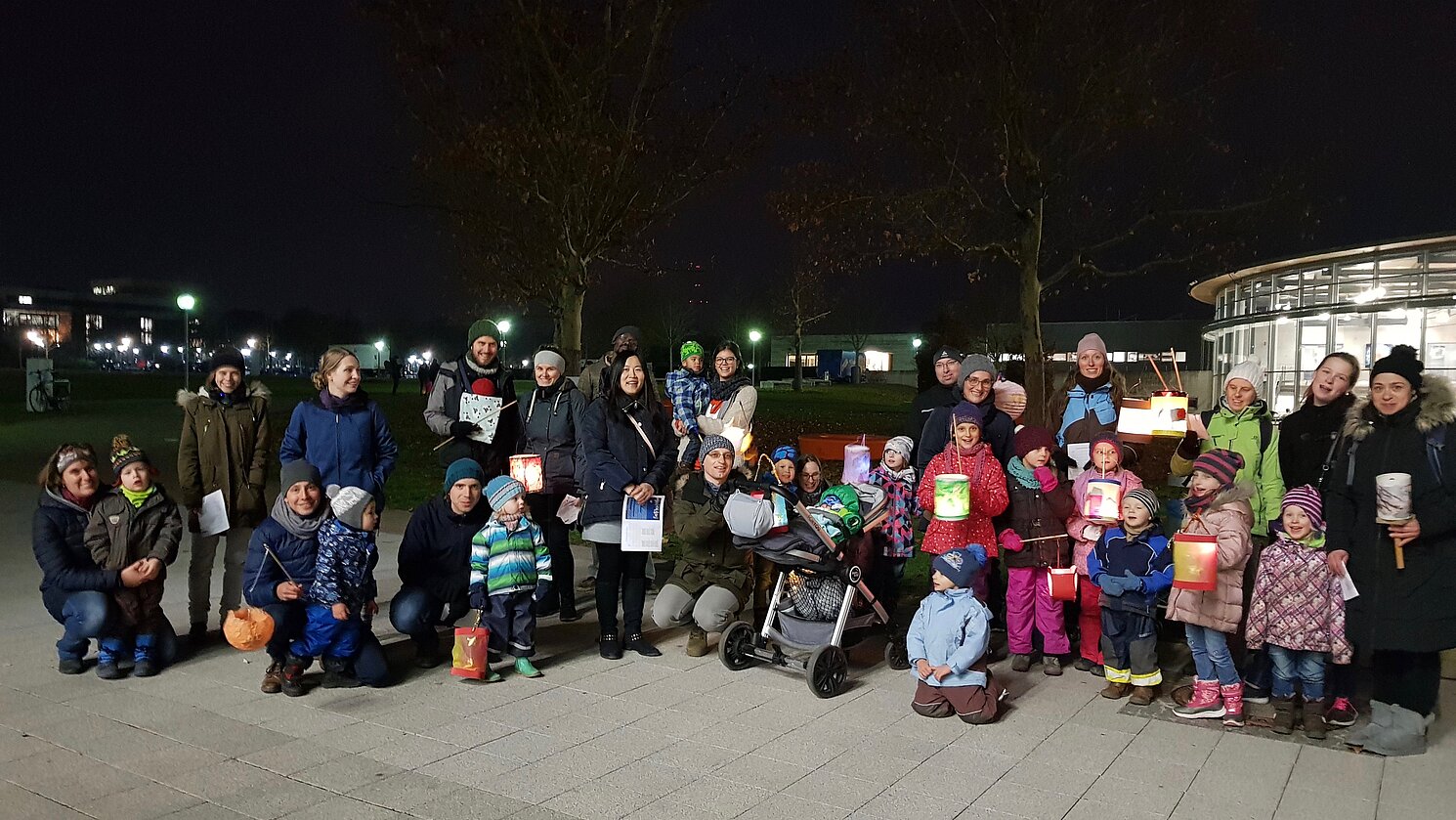 Kinder, Eltern und die Mitarbeiterinnen des Familienbüros der OTH Regensburg beim zweiten Laternenumzug mit bunten Lampions im Winter 2018. Foto: Katrin Liebl
