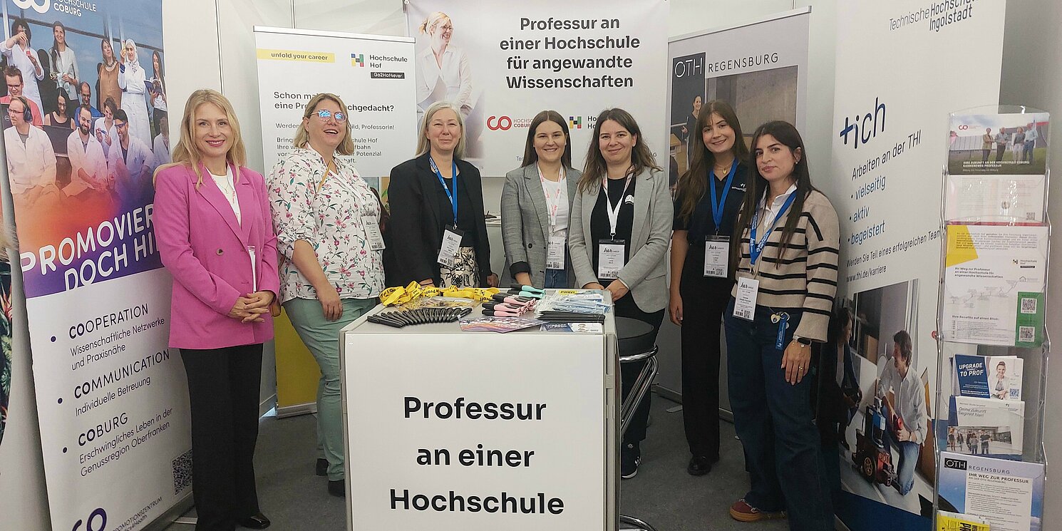 Sieben Frauen stehen an einem Messestand