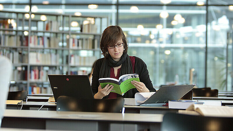 Eine Studentin in der Bibliothek der OTH Regensburg. Die Bewerbungsfrist für ein Studium an der OTH Regensburg läuft. Die Allgemeine Studienberatung bietet Beratung rund um alle Fragen zur Studienbewertung.