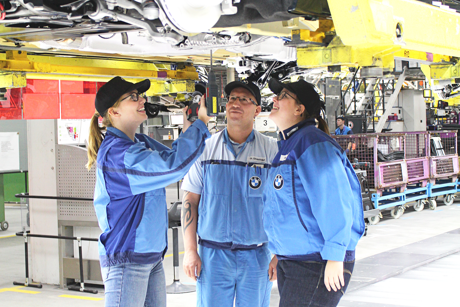 Zwei Studentinnen besichtigen mit Vorarbeiter Thomas Ehrentraut den Bereich Montage des BMW Werks Regensburg Zwei Studentinnen besichtigen mit Vorarbeiter Thomas Ehrentraut den Bereich Montage des BMW Werks Regensburg