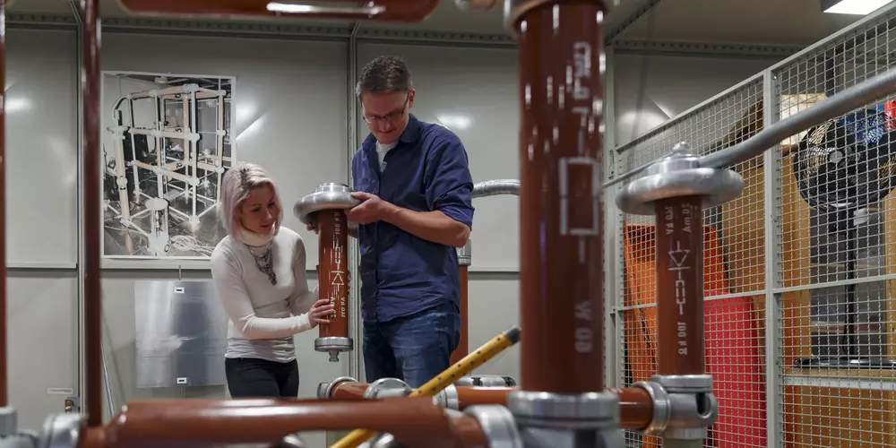 Zwei Studierende bearbeiten einen Aufbau für Hochspannungstechnik.