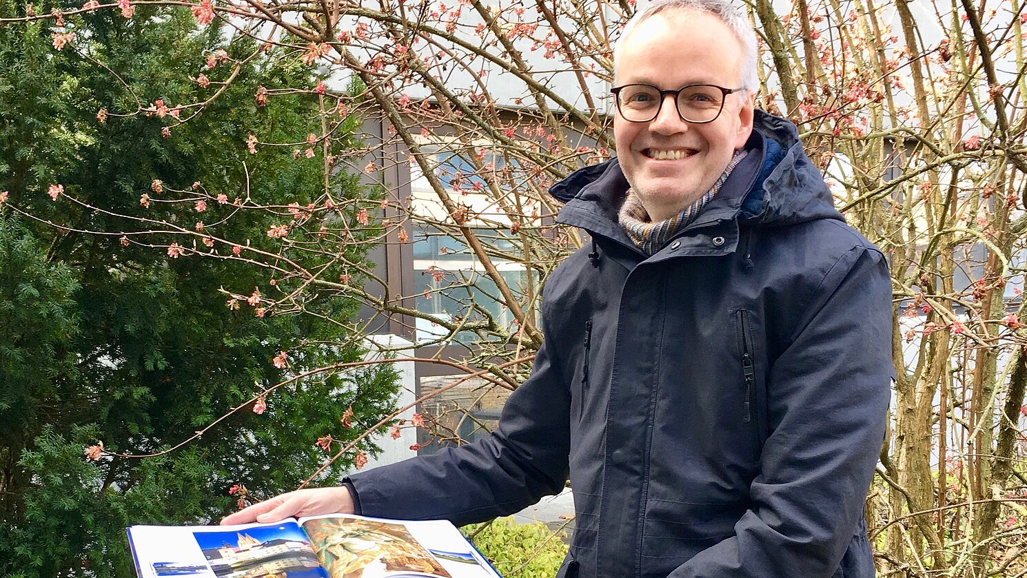 Peter Hillmer von der Hochschulbibliothek Regensburg vor der Installation zum Thema "Was soll bleiben? Die Vielfalt kultureller Überlieferung".