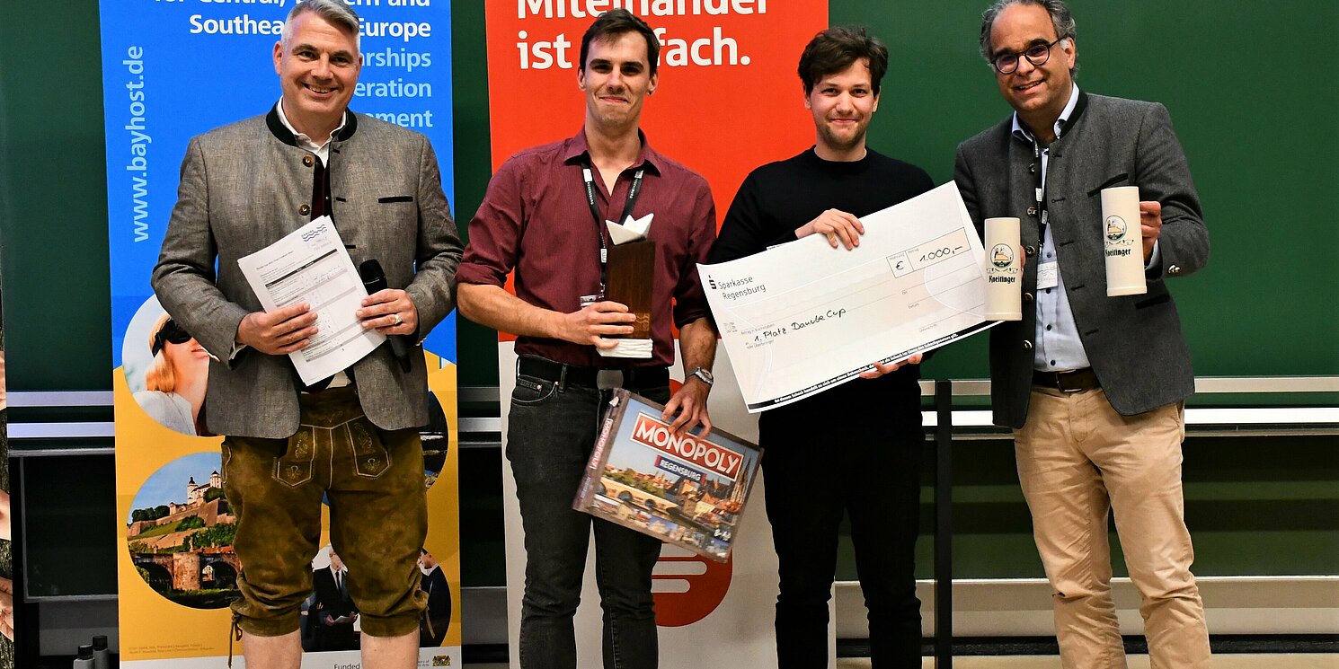 Das Budapester Team „Gellit“ gewann den Danube Cup 2023. Es gratulierten Prof. Dr. Sean Patrick Saßmannshausen (links) und Projektkoordinator Wolfgang Voigt (rechts). Foto: Simone Grebler/OTH Regensburg