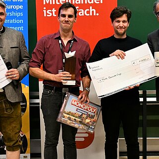 Das Budapester Team „Gellit“ gewann den Danube Cup 2023. Es gratulierten Prof. Dr. Sean Patrick Saßmannshausen (links) und Projektkoordinator Wolfgang Voigt (rechts). Foto: Simone Grebler/OTH Regensburg