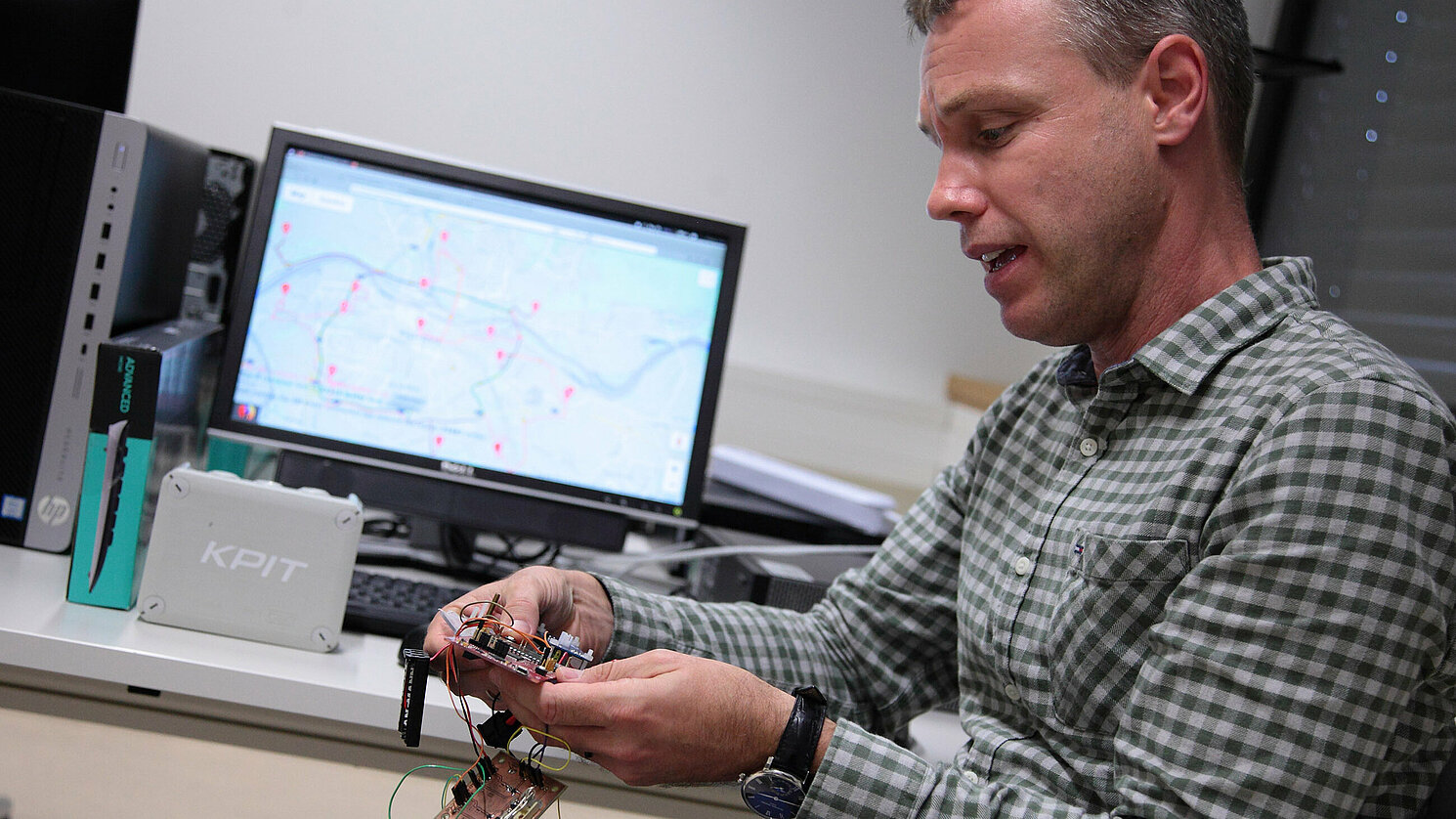 Prof. Dr. Jan Dünnweber von der OTH Regensburg vor seinem Routenoptimierungsprogramm. In Händen hält er das Innere eines Sensors. Mittels Künstlicher Intelligenz werden beispielsweise die Fahrten zu Müllcontainern optimiert. Prof. Dr. Jan Dünnweber von der OTH Regensburg vor seinem Routenoptimierungsprogramm. In Händen hält er das Innere eines Sensors. Mittels Künstlicher Intelligenz werden beispielsweise die Fahrten zu Müllcontainern optimiert.