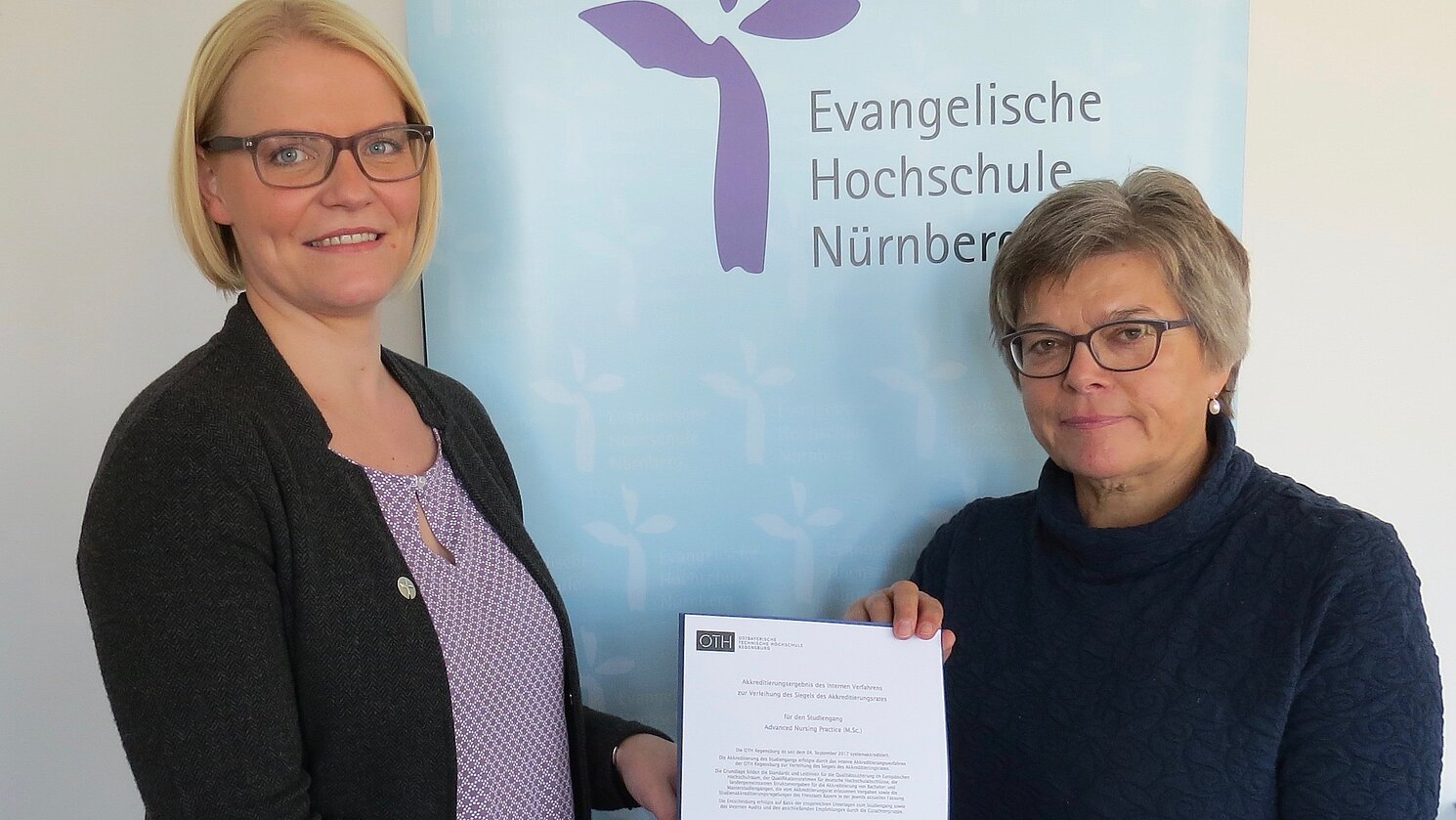 Die Präsidentin der Evangelischen Hochschule Nürnberg Prof. Dr. Barbara Städtler-Mach (rechts) überreicht die Akkreditierungsurkunde an die Nürnberger ANP-Studiengangleiterin Prof. Dr. Susanne Schuster (links). Foto: EVHN