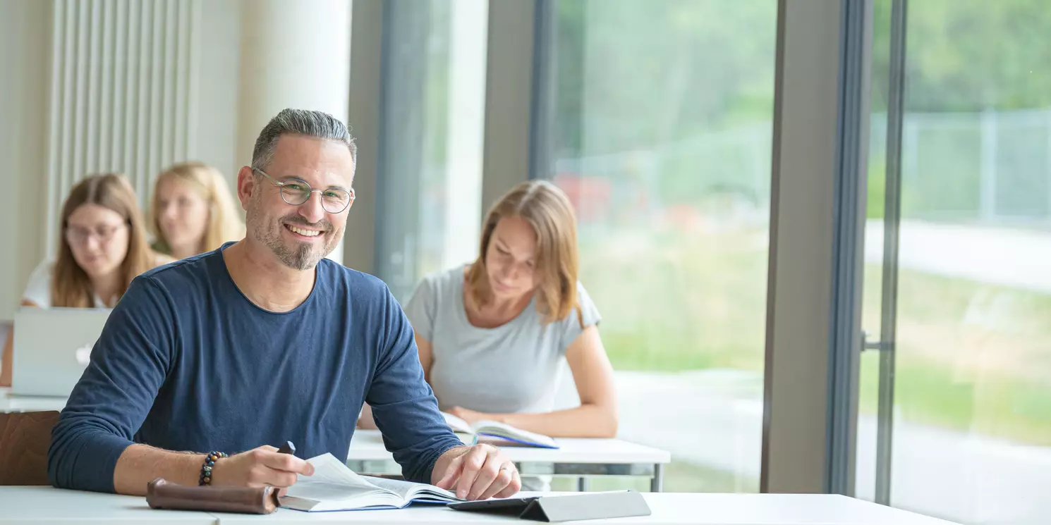 Pflegemanagement berufsbegleitend studieren Studierende arbeiten und lernen in einem Seminarraum.