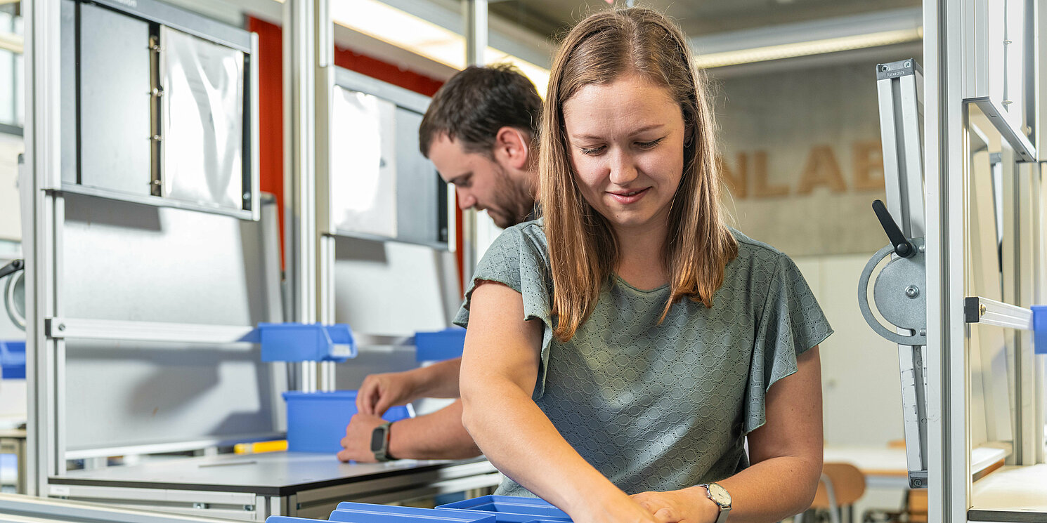 Studierende arbeiten im LeanLab an einer Fertigungsstrecke. 