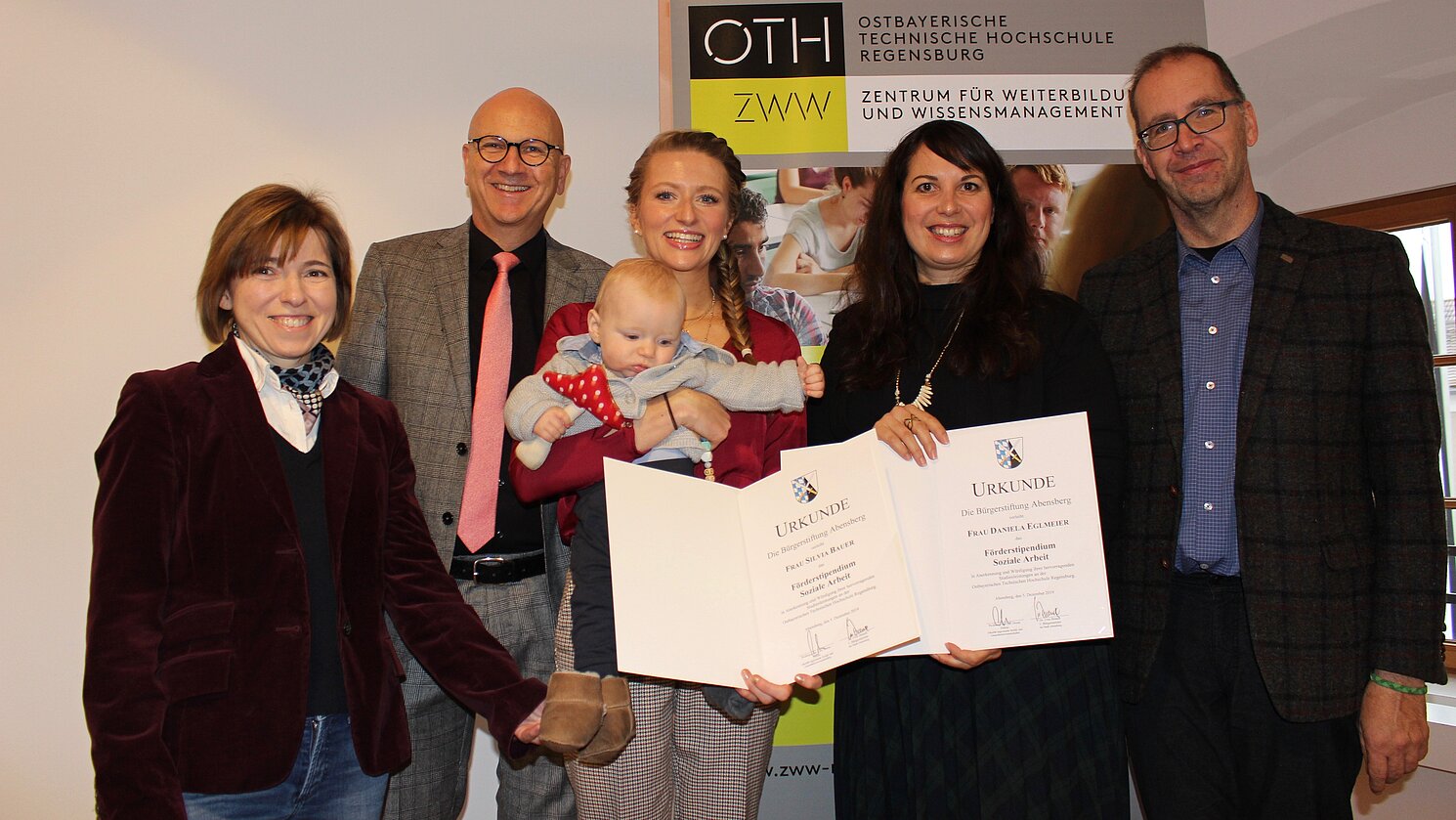 Abensberg: Von links: die Fakultätsreferentin des berufsbegleitenden Bachelorstudiengangs Soziale Arbeit von der OTH Regensburg Jana Faerber, der Erste Bürgermeister Dr. Uwe Brandl von Abensberg, die Preisträgerinnen Silvia Bauer mit Sohn Quirin und Daniela Eglmeier sowie Dekan Prof. Dr. Carl Heese.