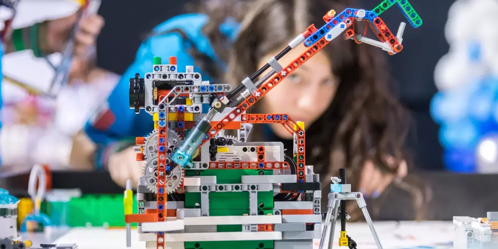 Foto Lego Roboter mit Personen im Hintergrund