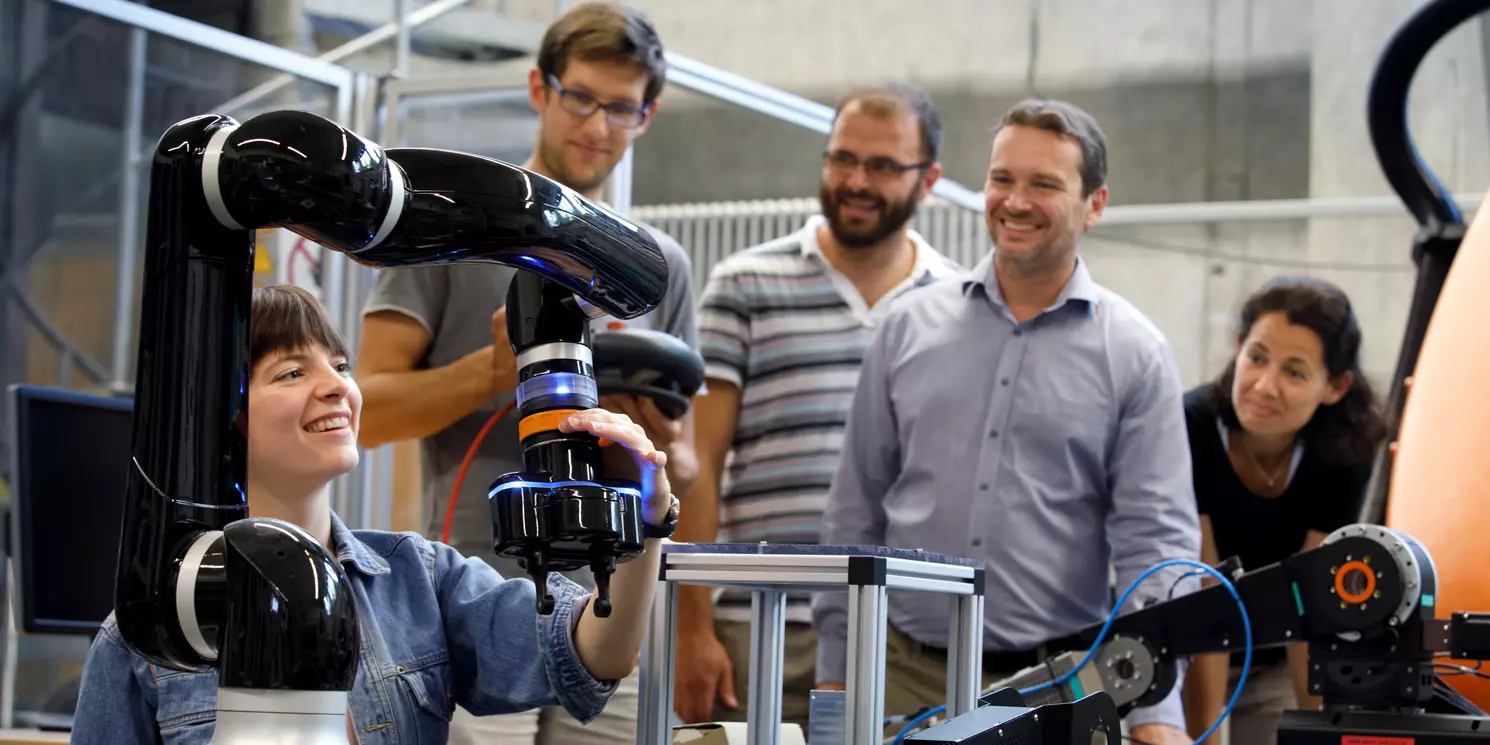 Modulstudien Systemtechnik berufsbegleitend absolvieren Fünf Studierende arbeiten in einem Labor an technischen Geräten