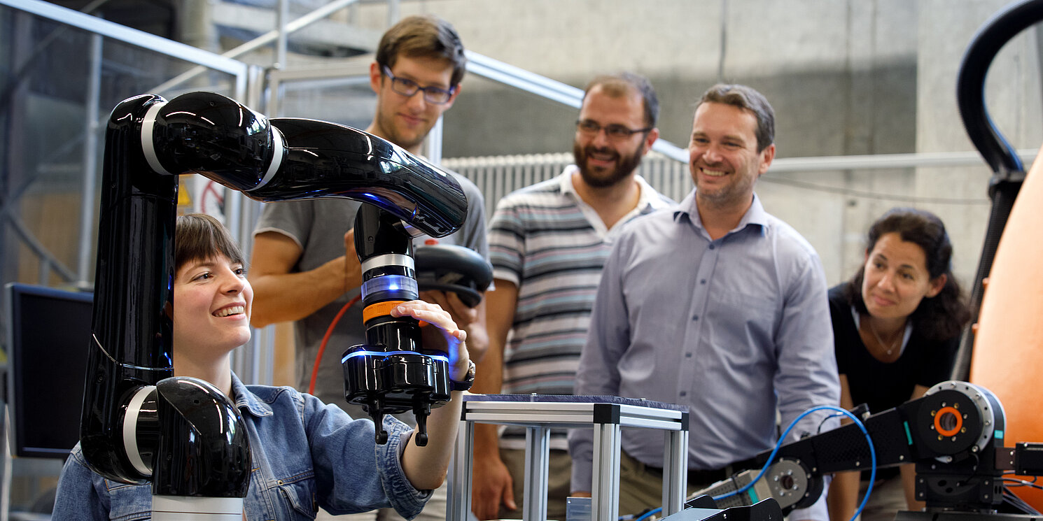 Fünf Studierende arbeiten in einem Labor an technischen Geräten