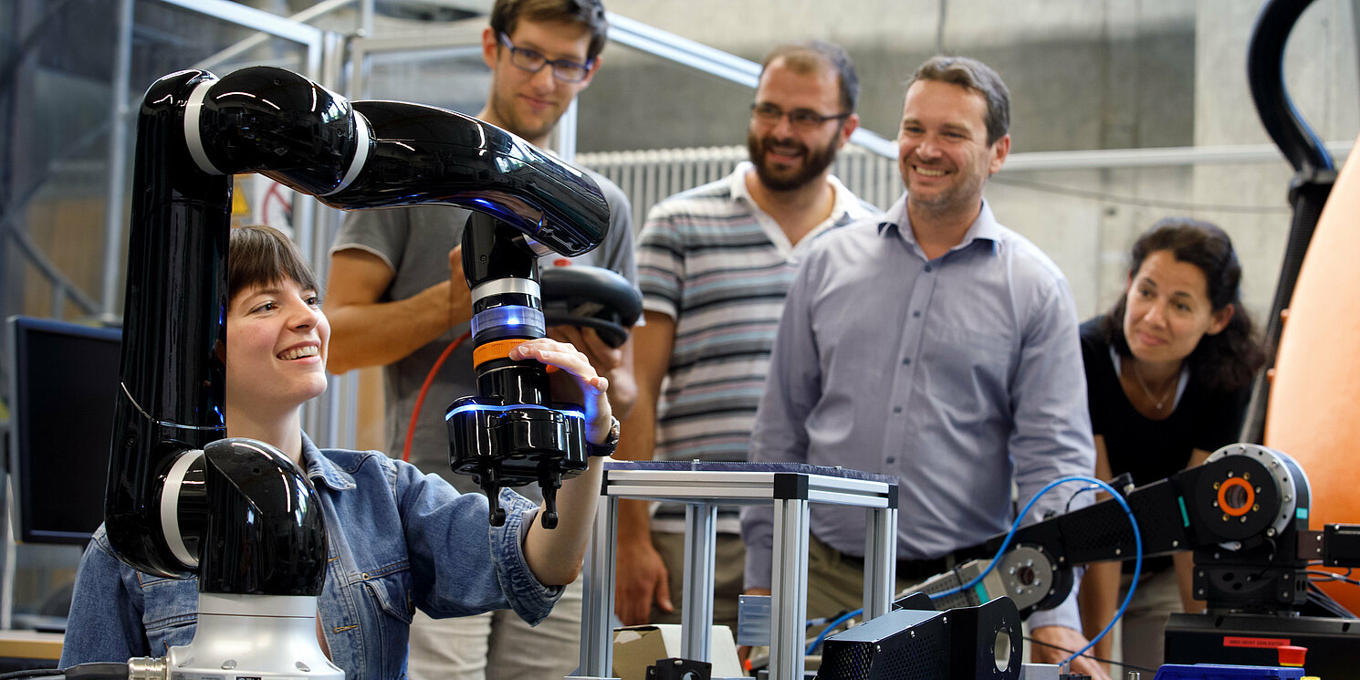 Zentrum für Weiterbildung und Wissensmanagement Fünf Studierende arbeiten in einem Labor an technischen Geräten