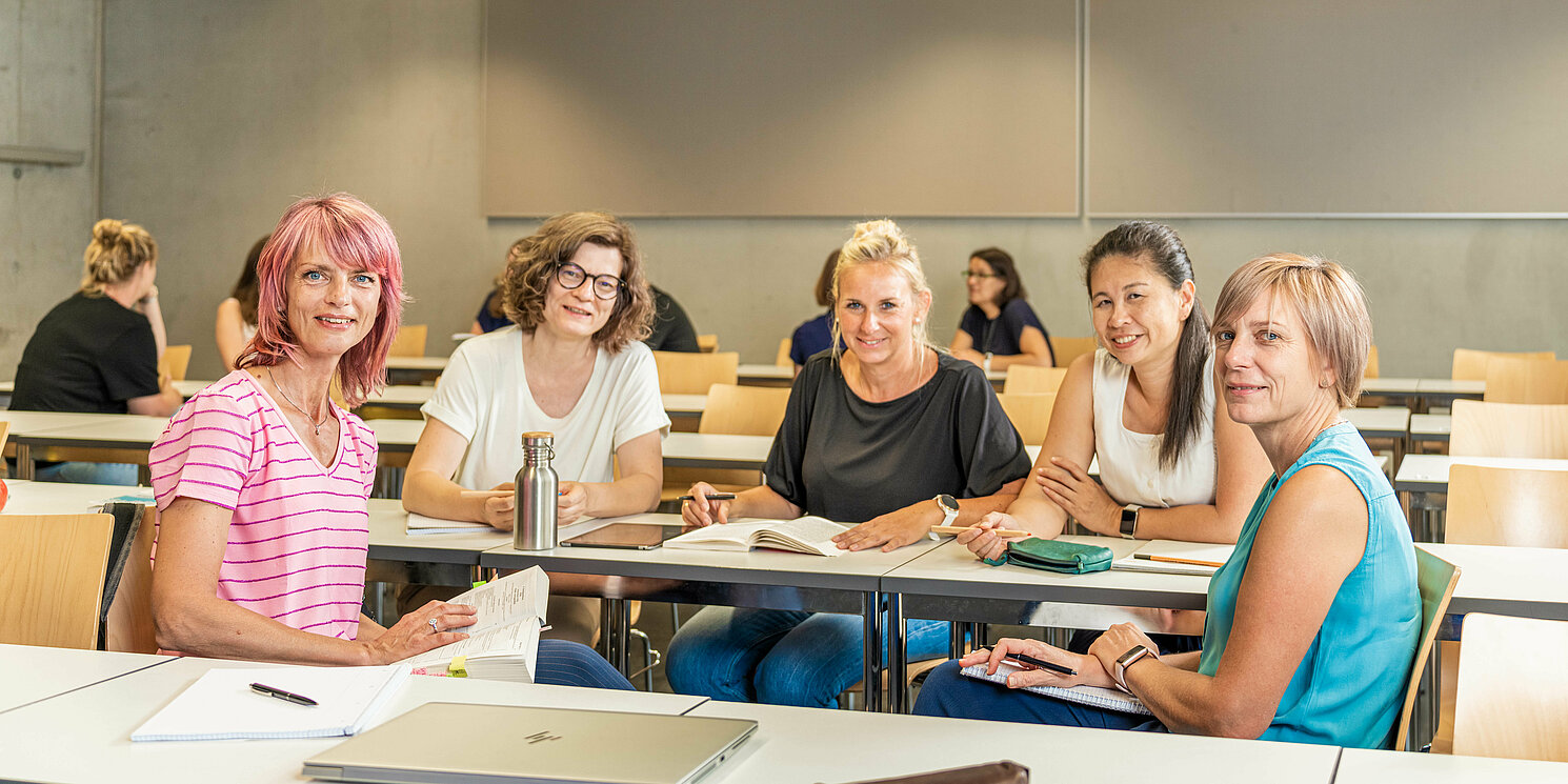 Studierende arbeiten in Gruppen in einem Seminarraum. 