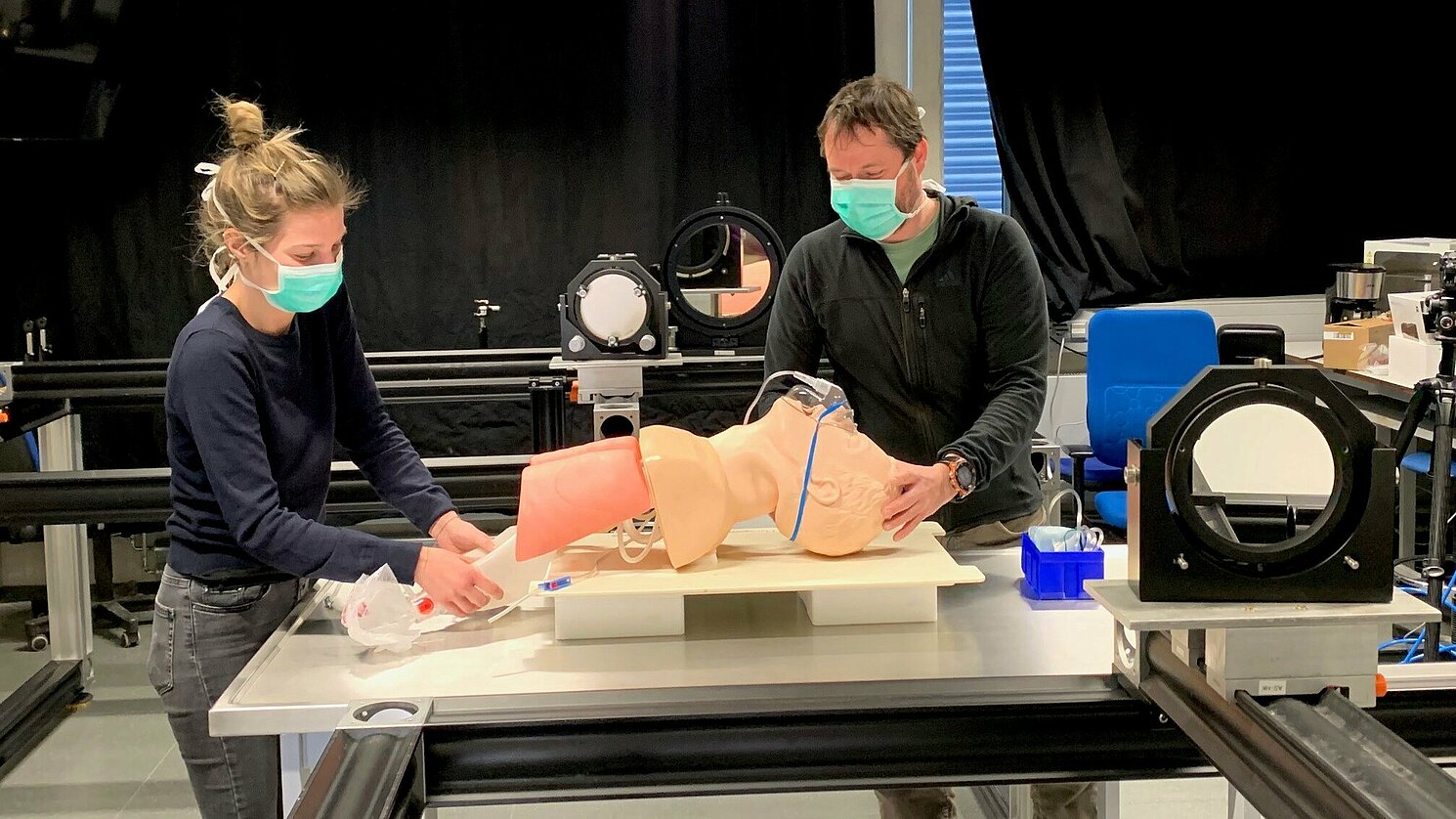 Das Forscherteam um Prof. Dr.-Ing. Lars Krenkel (rechts) ermittelt mittels optischer Strömungsmesstechniken, wie sich kleinste Schwebeteilchen (Corona-Viren) mit Luftströmungen bewegen. Mit im Bild Melina Tauwald, Wissenschaftliche Mitarbeiterin, Labor Biofluidmechanik.