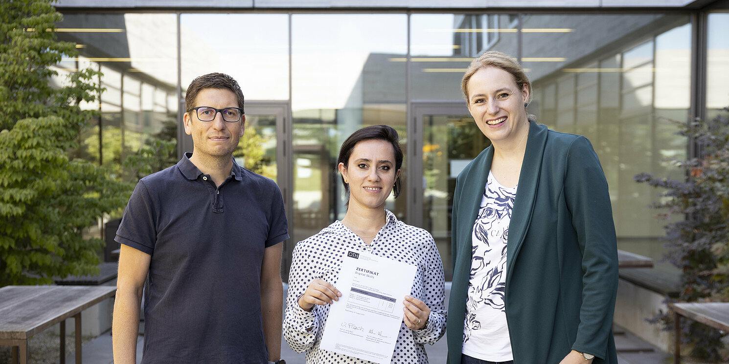 Prof. Dr. Markus Heckner (links) und Prof. Dr. Ulrike Plach freuten sich, das erste Abschlusszertifikat des Zusatzstudiums “Digital Skills” an Alumna Evin Kaya übergeben zu dürfen. Foto: OTH Regensburg/Katharina Scheidig