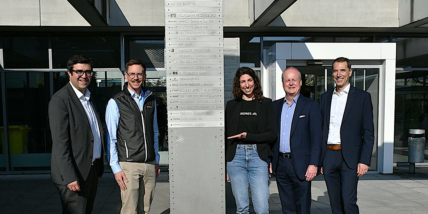 Um die Stifter-Stele an der OTH Regensburg haben sich von links nach rechts versammelt: Mathias Semmelmann, Mitglied des Stiftungsvorstands, Florian Gebhard, Head of People and Communications Krones.digital, Verena Brunner, Employer Branding Krones.digital, Stiftungsvorsitzender Dr. Bernd Waffler, Kanzler Utto Spielbauer.
