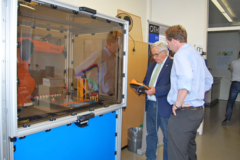 Bürgermeister Jürgen Huber (links) mit dem "Siedler von Catan"-spielenden Roboter und Prof. Dr. Martin Weiß, Leiter des Robotik-Labors (rechts). Bürgermeister Jürgen Huber (links) mit dem "Siedler von Catan"-spielenden Roboter und Prof. Dr. Martin Weiß, Leiter des Robotik-Labors (rechts).