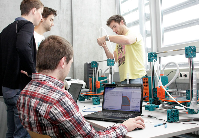 Studierende bei der Projektarbeit über 3D-Drucker.