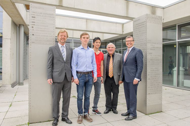 Vor den Stelen zur Stiftung zur Förderung der OTH Regensburg:  (von links) Präsident der OTH Regensburg, Prof. Dr. Wolfgang Baier, die Stipendiaten Mykyta Brem und Nguyen Ngoc Than, Dipl.-Kfm. Gert Wölfel, Vorsitzender im Stiftungsvorstand und Dipl.-In