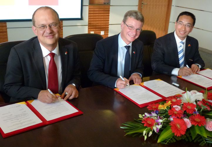Staatssekretär Bernd Sibler (Mitte) und Prof. Dr. Thomas Fuhrmann, Vizepräsident der OTH Regensburg (links), bei der Unterzeichnung einer Kooperationsvereinbarung mit der Zhejiang University of Science and Technology (rechts: Prof. Dr. Zheng Youqu, Vize