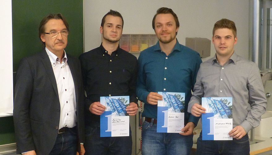 Wolfgang Hausladen, CRD Head of Mechatronics der Krones AG, prämiert das studentische Siegerteam Maximilian Schottenloher, Markus Pehl und Andreas Hack von der OTH Regensburg (von links).